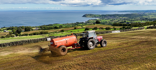 Aerial Photo of Massey Ferguson 390T Tractor and Abbey Tanker spreading manure slurry in a field on a farm in UK 09-09-23