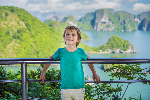 Boy traveler in Halong Bay. Vietnam. Travel to Asia, happiness emotion, summer holiday concept. Picturesque sea landscape. Ha Long Bay, Vietnam. After coronavirus COVID 19.