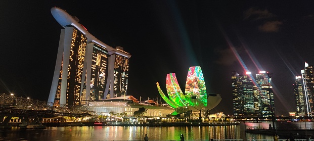 Evening view of the Singapore Merlion statue at Marina Bay against Singapore skyline. The Merlion is a well known marketing icon of Singapore depicted as mythical creature with a lion's head and a body of a fish.