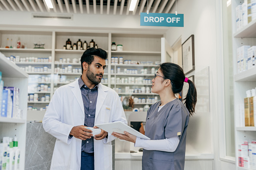 Male pharmacist and female pharmacist working in a drugstore