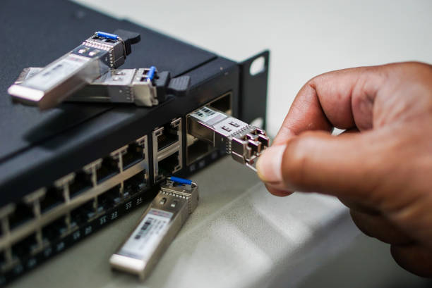Optical gigabit sfp modules for network switch. Network administrator installing sfp module for fiber optics cable connecting. Optical gigabit sfp modules for network switch. Network administrator installing sfp module for fiber optics cable connecting. transceiver stock pictures, royalty-free photos & images