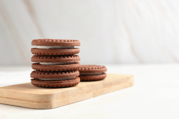 istock Tasty chocolate sandwich cookies with cream on light table, space for text 1706964023