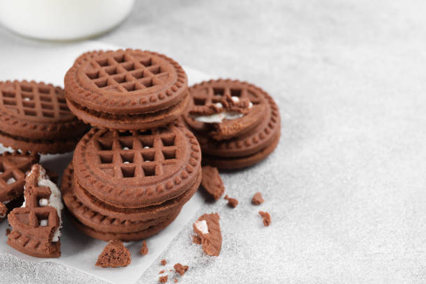 istock Tasty chocolate sandwich cookies with cream on light grey table, space for text 1706964671