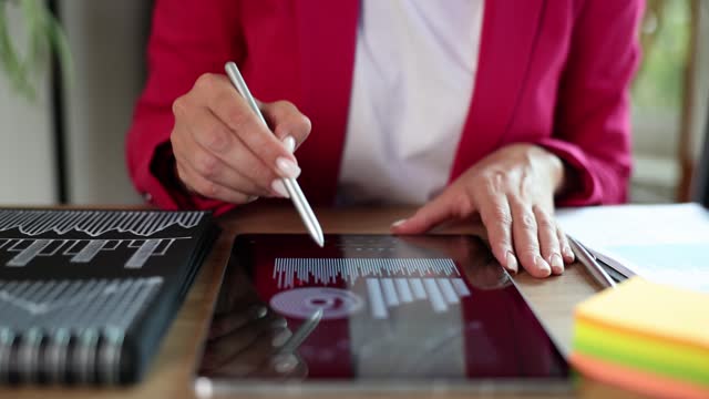 A woman in the office draws a stylus on a tablet