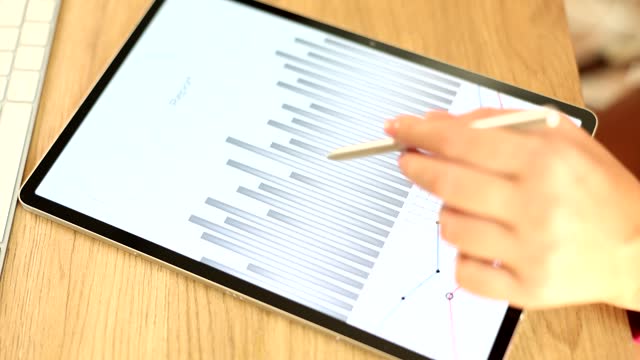 Hand scrolling reports on a tablet with a stylus