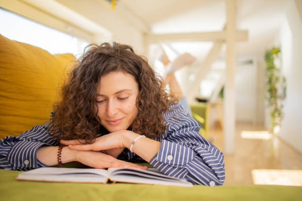 istock Woman reading book at home 1706983719