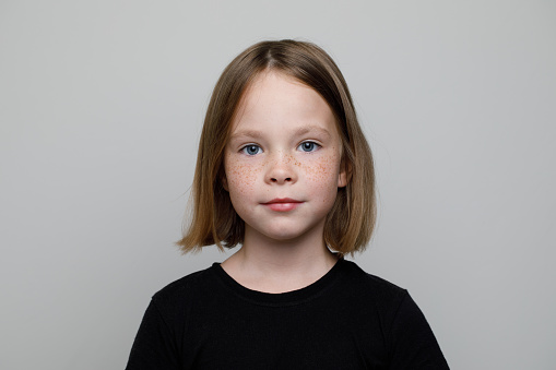 Girl looking at camera, yellow background.