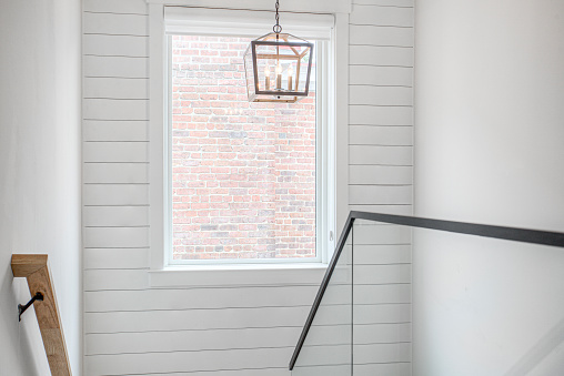 Well-lit interior with large windows, creating bright ambiance. Rustic modern farmhouse lantern adds charm. Minimalist and filled with natural light.