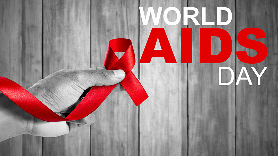 Human hand showing red ribbon awareness. World Aids Day concept