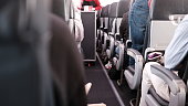 People sitting in the aisle of the plane.