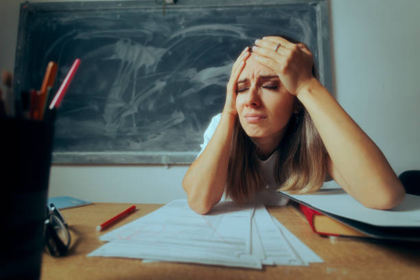 istock Stressed Teacher Grading Papers Suffering a Migraine 1707042699