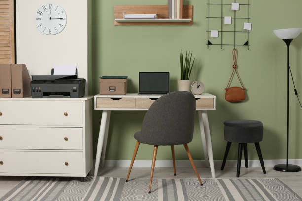 istock Stylish workplace with laptop and modern printer indoors 1707046074