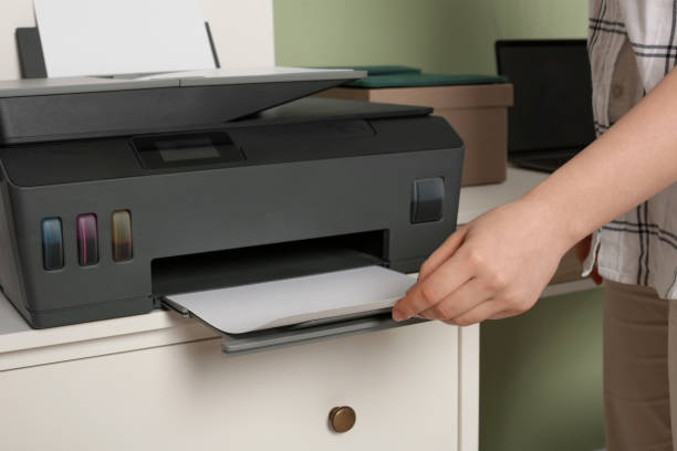 istock Woman using modern printer at workplace, closeup 1707046075