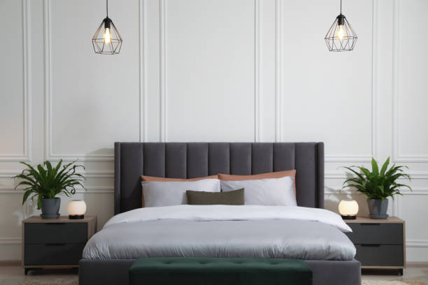 istock Stylish bedroom interior with large comfortable bed and ottoman 1707046120
