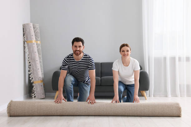 istock Smiling couple unrolling carpet on floor in room 1707081711