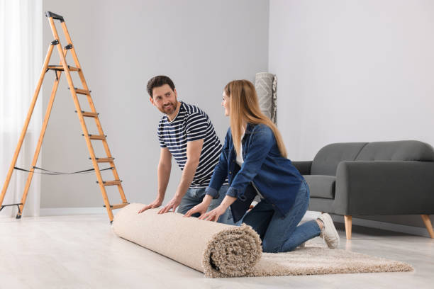 istock Smiling couple unrolling new carpet in room 1707082782