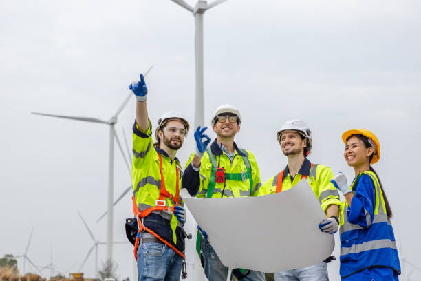 istock Teamwork engineer worker wearing safety uniform holding and reading blueprint at wind turbine field renewable energy. technology protect environment reduce global warming problems. 1707190636