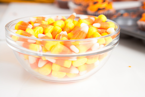 Clear bowl of candy corn on white kitchen counter