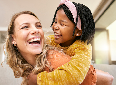 Piggyback, bonding and mother and child in foster care on mothers day with love, smile and support. Family, interracial and African girl with a playful hug for her mom after adoption in their home