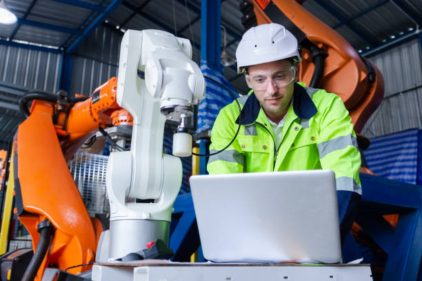 istock man engineer using laptop control robot arm automate. robotic automation in line production at industrial. Test performance of robotic in factory. 1707256726