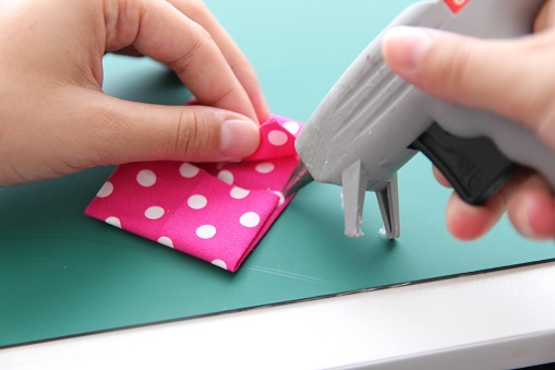 Pink polka dot fabric bow tie craft with a hot glue gun