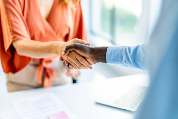 istock Business persons shaking hands on a meeting in board room. 1707277332