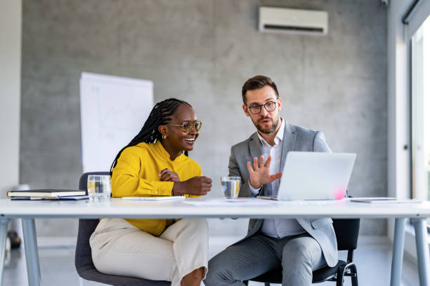 istock Two young business people having a successful meeting in modern office. 1707284587