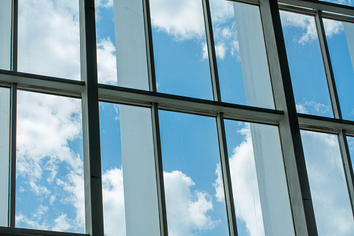 Reflection of blue sky and cloud on glass building. Bright light on glass building, persprctive view.