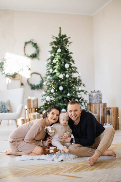 istock Cheerful parents playing with daughter near Christmas tree 1707303509