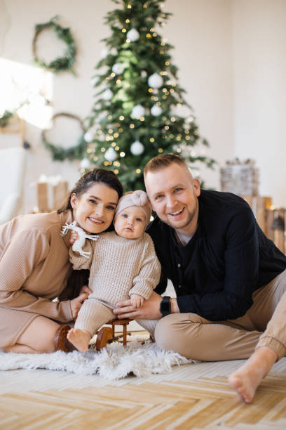 istock Cheerful parents playing with daughter near Christmas tree 1707303564