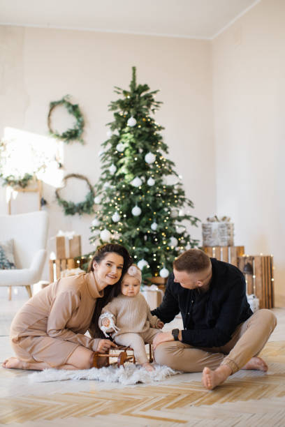 istock Cheerful parents playing with daughter near Christmas tree 1707303758