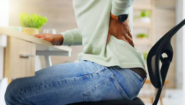 Man, back pain and body injury in home from poor posture, wound or arthritis risk. Closeup, backpain and medical health of spine fracture, chiropractic stress or scoliosis problem of sitting on chair