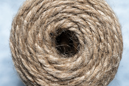 High-quality handmade coil made of natural hemp rope, isolated on a white background. Rustic beige cord made of eco material