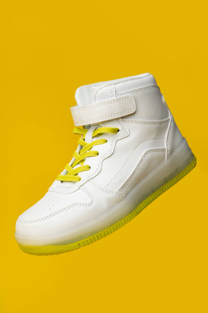 istock White sneakers with yellow neon laces on yellow background 1707331862