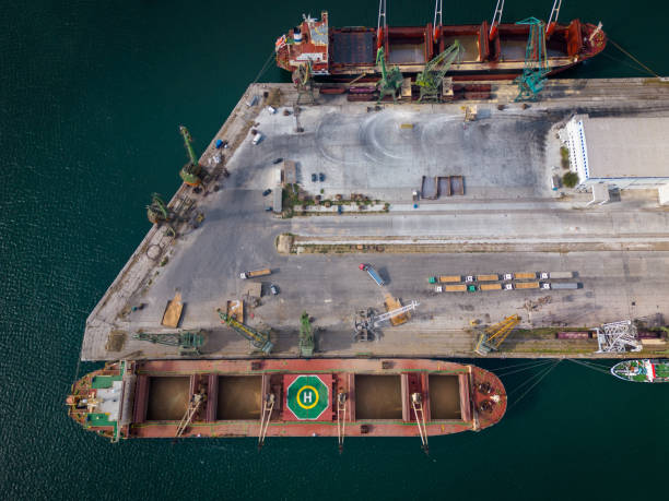 istock aerial view of a bustling seaport, where a massive cargo ship, a bulk carrier, is being loaded with wheat grains 1707360619