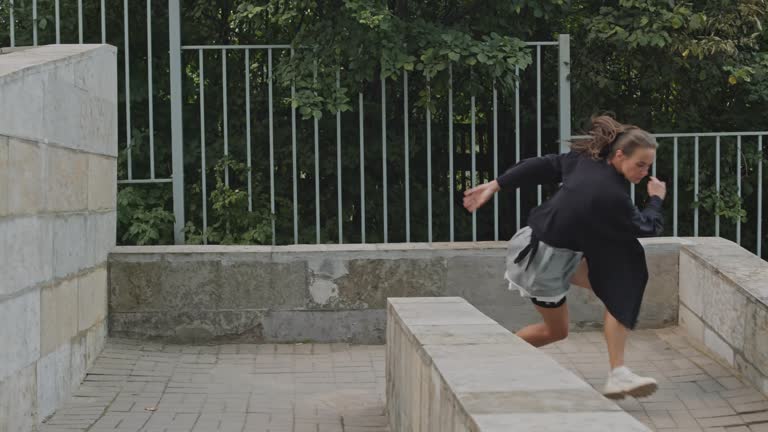 Female Parkourist Doing Somersault in City