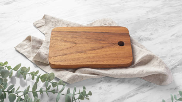 istock Wood board with linen napkin on white marble table 1707382043