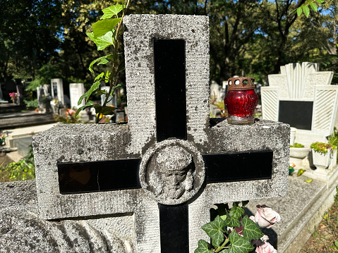 Stone cross on the tombstone in the public cemetery