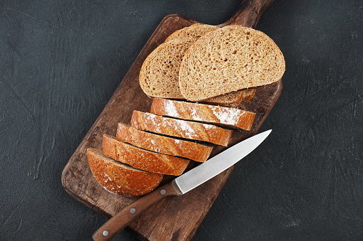 Sliced rye bread on cutting board. Whole grain rye bread