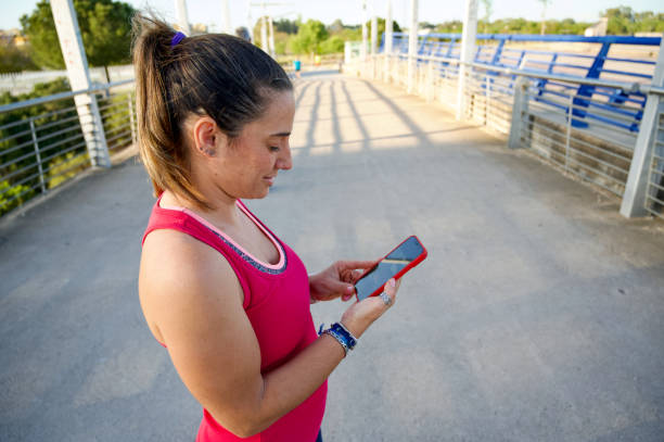 istock Beautiful woman using cell phone before going for a run outdoors 1707415886