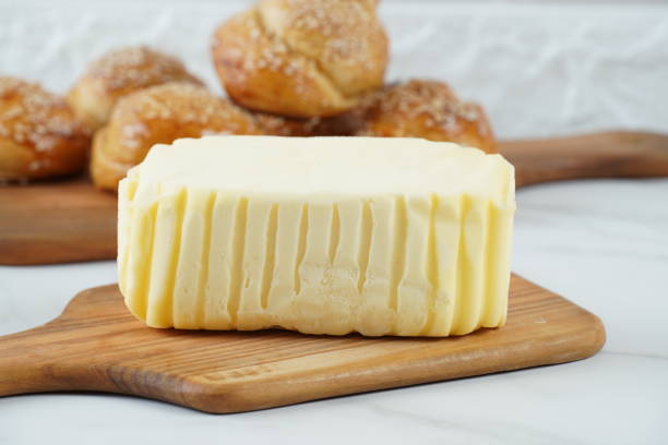 Block of fresh butter sliced on wooden cutting board Block of fresh butter sliced on wooden cutting board butter margarine isolated portion stock pictures, royalty-free photos & images