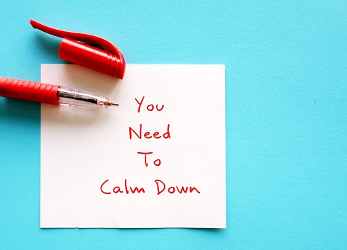 Red pen writing message note YOU NEED TO CALM DOWN - self-reminder to stop workplace drama, avoid conflicts and reduce toxicity in office environment