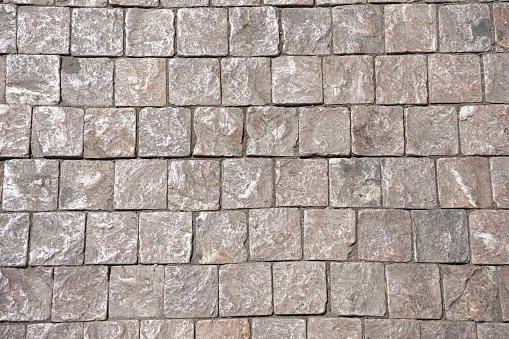 Stone pavement texture. Granite cobblestoned pavement background. Gray brick stone background.