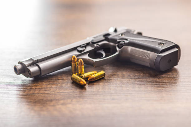istock Handgun and bullets on wooden table. 1707440834