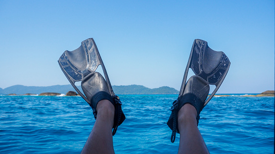 Close up Diver fins on the sea. Flippers in water. Diver fins. Active vacation at sea.