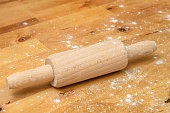 A rolling pin lying on the counter, sprinkled with white wheat flour