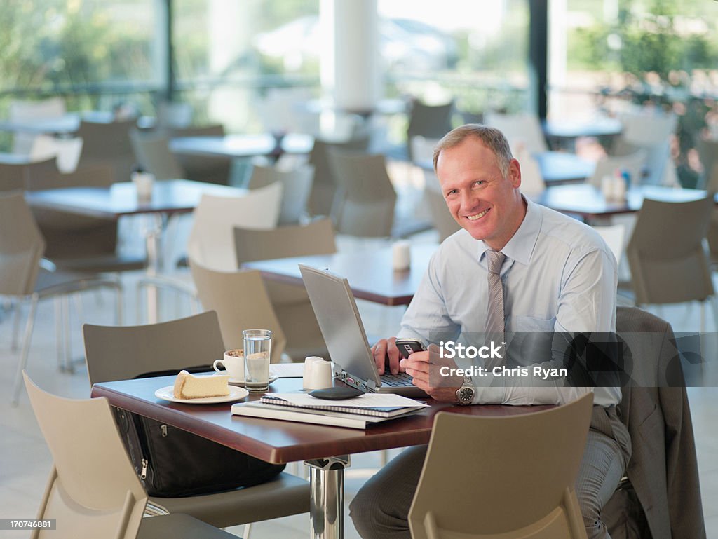 Empresário, olhando no celular na cafeteria - Foto de stock de Cantina royalty-free