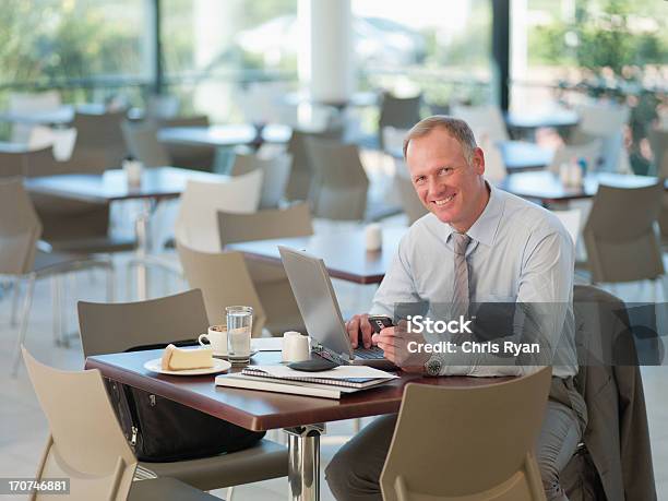 Foto de Empresário Olhando No Celular Na Cafeteria e mais fotos de stock de Cantina - Cantina, 45-49 anos, Adulto