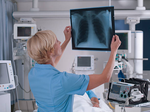 enfermera revisión de rayos x - x ray image radiologist examining using voice fotografías e imágenes de stock