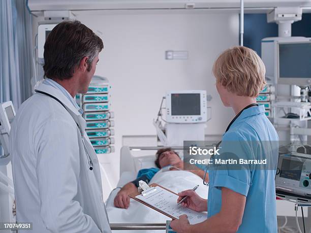 Médico Y Enfermera Hablando En La Unidad De Cuidados Intensivos Foto de stock y más banco de imágenes de Paciente